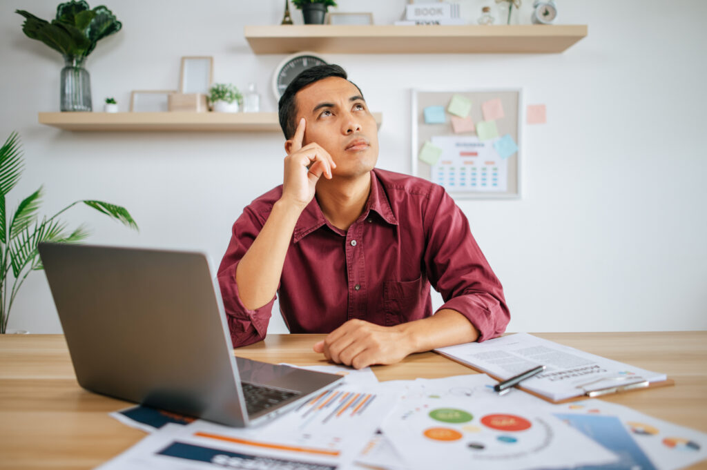A man works in an office with a laptop.