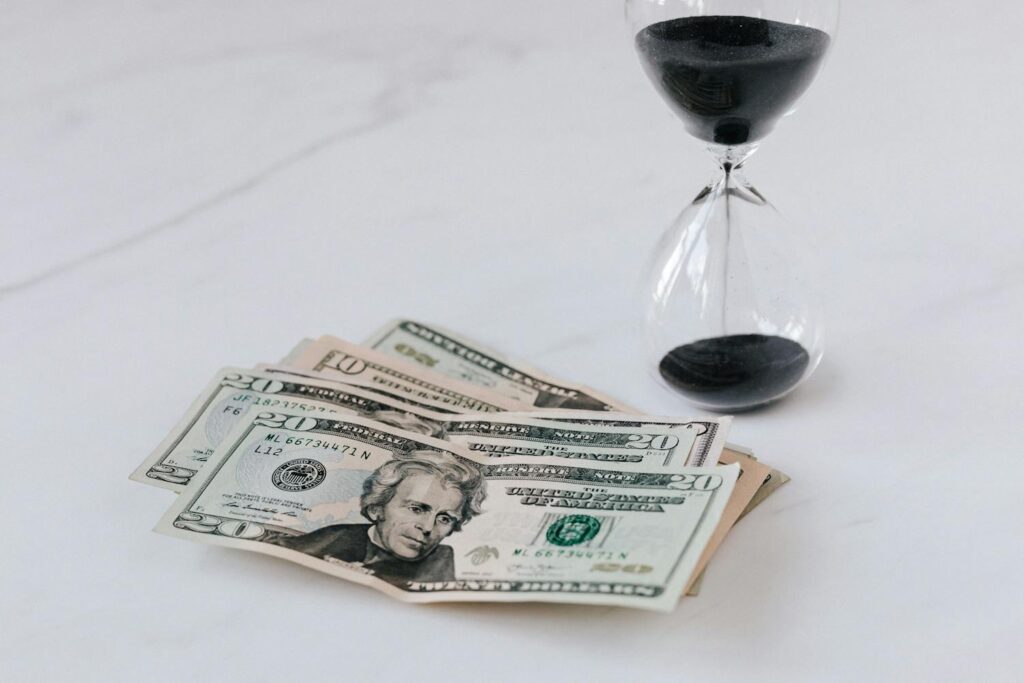 Hourglass near Heap of American Dollars
